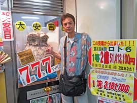 幸運を呼ぶふくろうのジャンボ福来郎とロト6で1等2億5千万円が出たという看板に挟まれて記念撮影